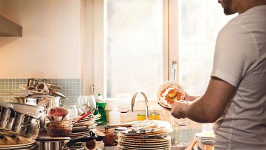 Cleaning with water - man cleans dirty dishes